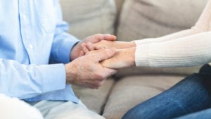 Holding hands with elderly person